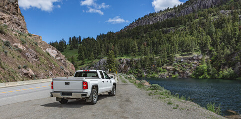 Pickup truck on the beautiful road along the mountain river and forest. © Elena_Alex