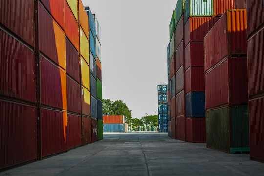 Wide empty container yard with stacked shipping containers forming open industrial space, freight logistics hub, global trade transportation concept, supply chain infrastructure background