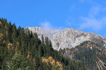 Morning view of snow-capped mountains and colourful forests in autumn at Jiuzhai Valley National Park in autumn, China