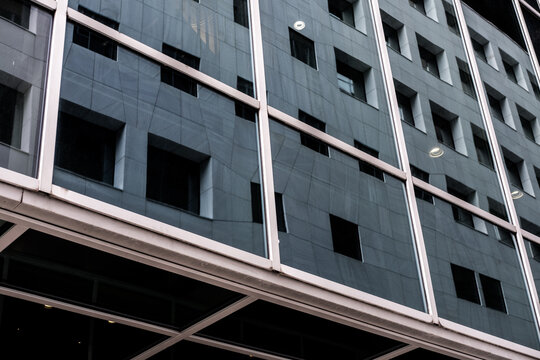 Modern urban architecture facade with structural grid and steel beams where windows follow geometry lines creating an abstract pattern in daylight