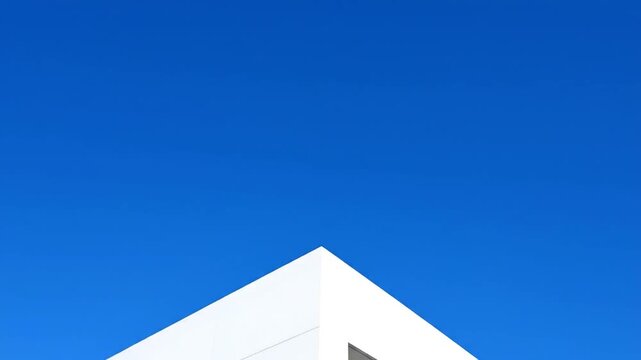 Minimalist architectural image white building corner against a clear blue sky