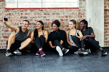 Fototapeta premium Friends, selfie and happy on gym floor for fitness, memory and bonding with post on web at wellness class. People, group and smile with photography, profile picture or social media at exercise club
