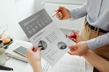 Team Meeting Analyzing Business Reports and Data Charts in Modern Office