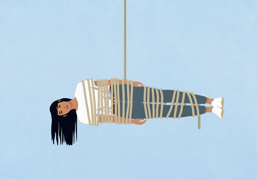 Woman wrapped in rope hanging horizontally on a blue background