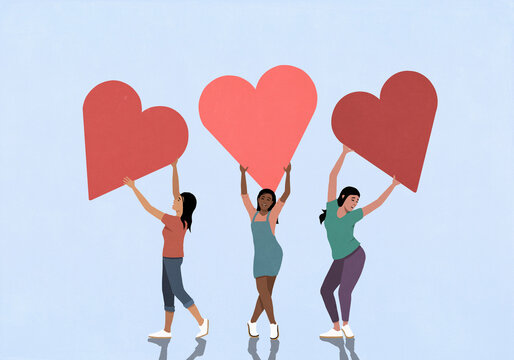 Happy young women holding large hearts overhead against blue background