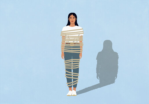 Rope wrapped around serious young woman against blue background