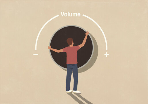 Man adjusting large volume dial against beige background