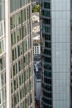 Vertical office skyscraper in Frankfurt Germany seen in aerial angle with glass architecture overlooking an urban street grid and city blocks