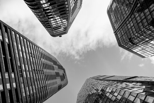 Frankfurt Germany urban tower skyscraper in monochrome shows glass architecture from strong perspective with high contrast and moody clouds