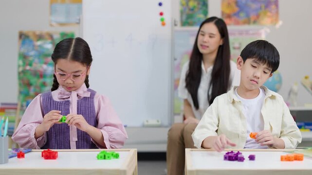 Asian Elementary Students Using Math Manipulatives with Teacher in Classroom