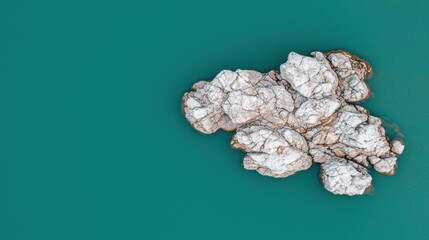 A cluster of white rocks with brown veins, set against a teal background.