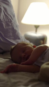 newborn baby sleeping on a bed at night