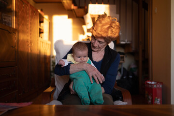 Great grandmother in her 80's holding her infant great granddaughter.