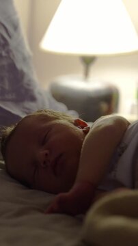 newborn baby sleeping on a bed at night