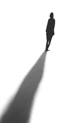 Silhouette of a person walking in darkness, cast in long shadow