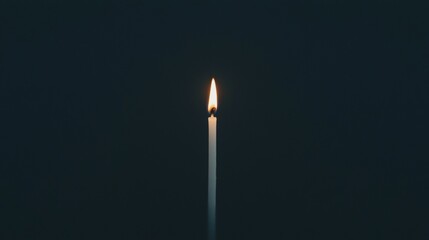 A single lit candle in the dark.