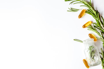 frame from rosemary, bottles, pills on white background top view