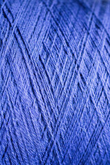 Textured thread on a spool of blue color, close-up shot © Olha K