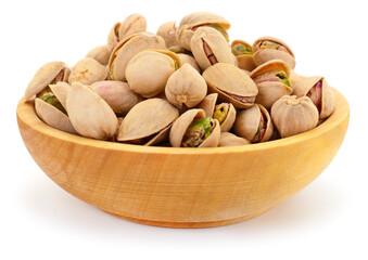 Wooden bowl filled with roasted salted pistachios in shells isolated on white background
