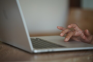 Close-up of hands typing on a laptop keyboard, remote work or digital nomad lifestyle.