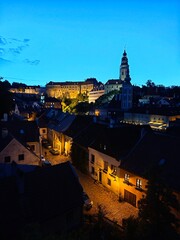 Title: Golden sunset over Cesky Krumlov Castle Tower and historic red roofs with sun flare, UNESCO world heritage site in South Bohemia Czech Republic
