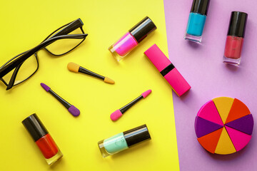 make up set on yellow and purple background top view