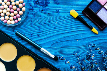 cosmetic palette and lavender flowers on wooden background