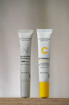 STRASBOURG, FRANCE - JANUARY 15, 2026 : A still life photographe of MADARA Niacinamide alternative face serum and Vitamin C cream bottle packaging. The product is displayed on a wooden surface, cream