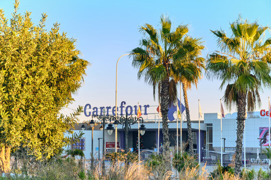 The Carrefour hypermarket brand is seen in Estepona Spain framed by palm trees and a clear blue sky. This retail store is a popular shopping destination in the coastal town of Estepona Spain.