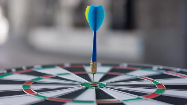 Close up of blue dart hitting bullseye on dartboard game for accuracy and focus concept