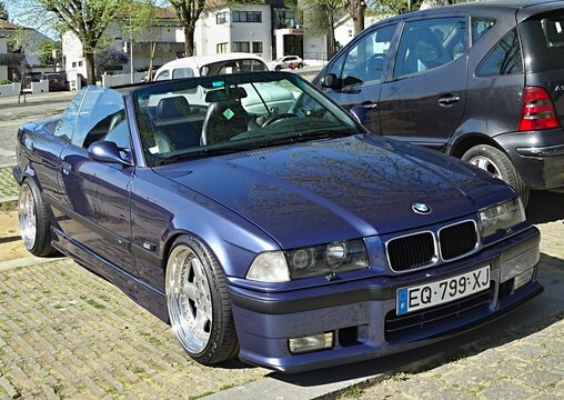 Blue BMW E36 convertible parked on street