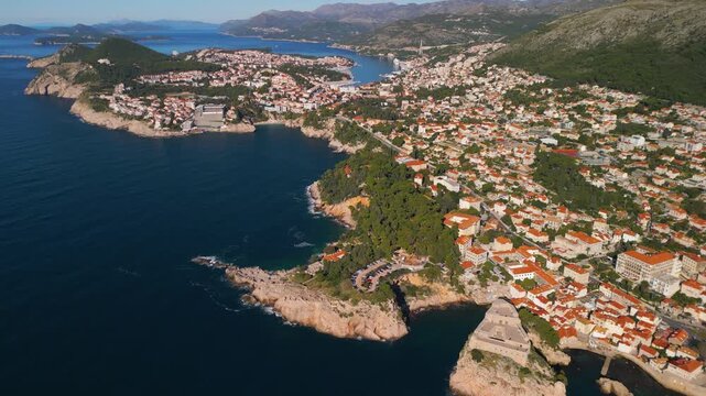 Aerial panoramic reveal of Dubrovnik coastline, Lapad peninsula and Adriatic islands. Cinematic 4K drone footage with camera tilt.