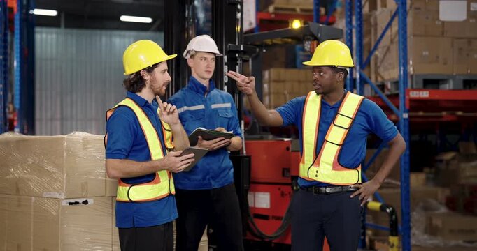 caucasian warehouse staff holding tablet while having conversation with logistic supervisor during cargo shipment planning near forklift teamwork expression and decision making captured in moment