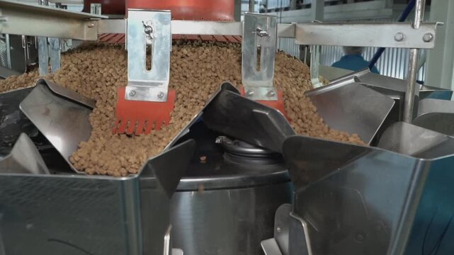 Multihead weigher machine precisely portions dry granular pet food on an automated industrial packaging line