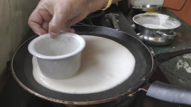 Fresh Dosa Batter Being Spread on Hot Tawa in South Indian Kitchen