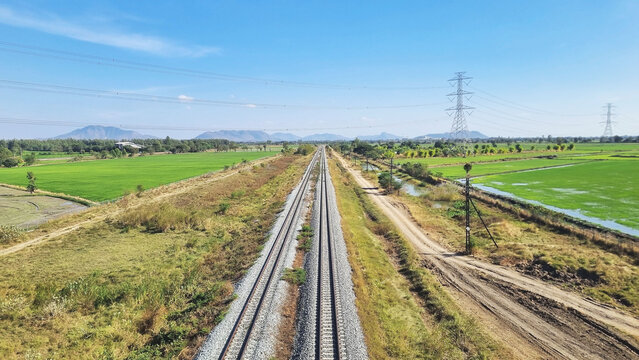 A photograph of a double-track railway heading towards northern Thailand, with beautiful natural scenery along the way.