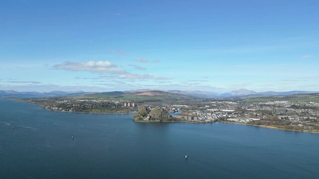 A stunning highaltitude aerial shot showing Dumbarton Castle on its volcanic plug, the River Clyde, and the surrounding Scottish town with ample copyspace in the sky.