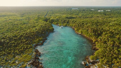 Aerial view of turquoise lagoon with yacht in tropical Yucatan forest Mexico. © Olga Gorkun