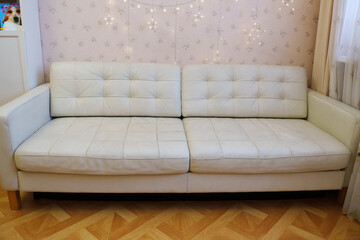 White sofa with wooden legs in a room with soft lighting and decor