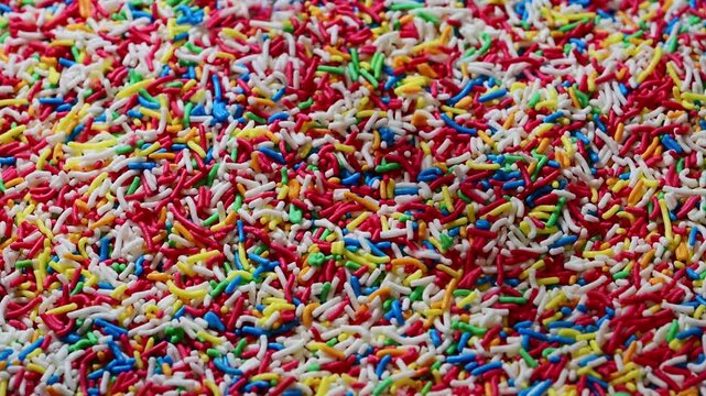 a dense layer of multi-colored sugar sprinkles in shades of red, blue, green, yellow, and white.