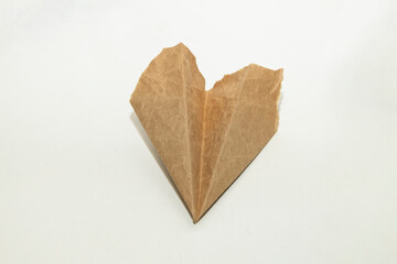The homemade plane made from old vintage torn brown paper on white background