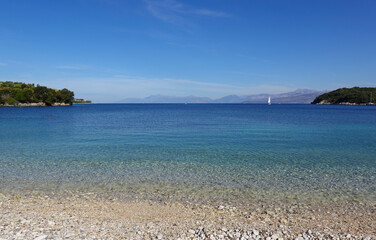 Obraz premium A gorgeous summertime view across the blue waters of Avlaki Bay on the coast of Corfu, Greece. 
