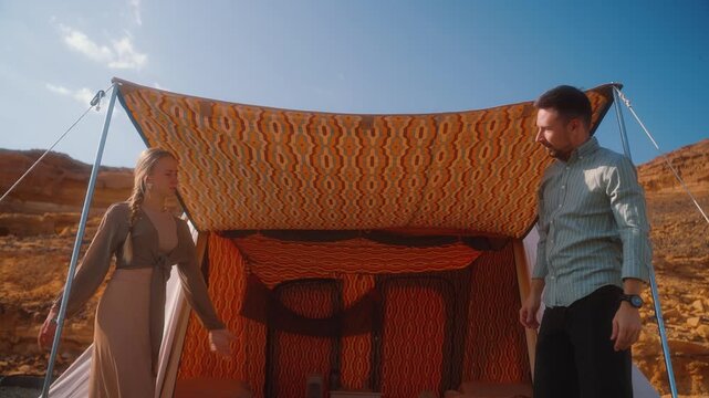 Setting up a tent in the camp by couple of travelers. Eastern style of traditional Arabic tent in the desert, shot in AlUla, Saudi Arabia
