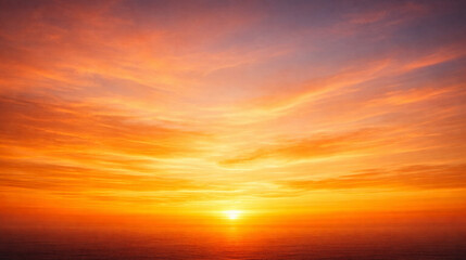 Obraz premium Golden Ocean Sunset with Warm Orange and Yellow Sky, Soft Clouds, and Calm Sea Horizon Creating a Peaceful and Inspirational Background