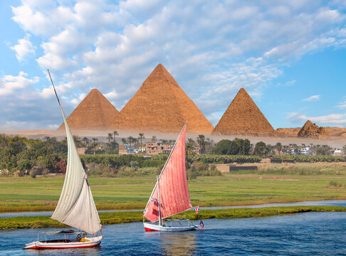 Beautiful Nile scenery with traditional Felluca sailing boat in the Nile on the way to Giza pyramids - Cairo, Egypt