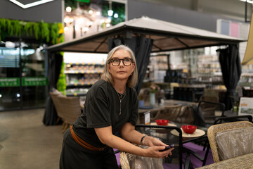 Woman pondering in a home decor store while exploring patio furniture options and styles