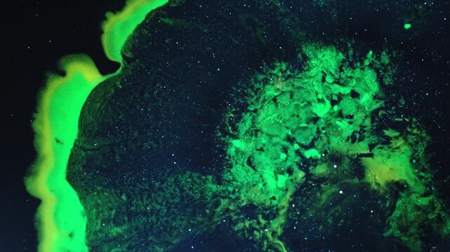 Vivid green ink mixing in macro shot, capturing a cosmic feel