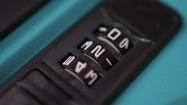 Secure suitcase with combo lock, Hands set combination on teal suitcase with textured surface, Closeup of hands adjusting numeric lock on stylish teal travel suitcase