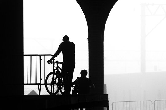 Ciclistas empurrando bicicleta.  