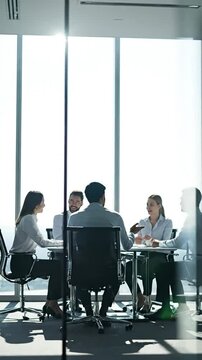 Blurred Silhouette of Business People Having a Meeting in a Modern Office Boardroom with Large Windows and Bright Natural Light